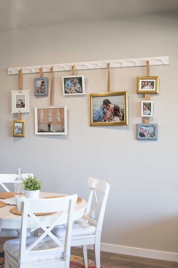Far shot of picture frames hanging on the wall by a kitchen table