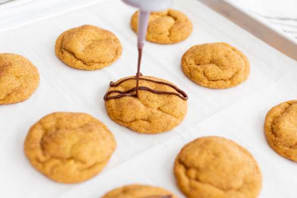 chocolate being drizzled over pumpkin snickerdoodles