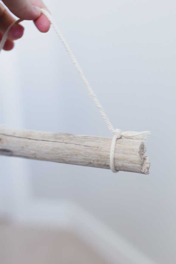 piece of driftwood hanging by a macrame cord