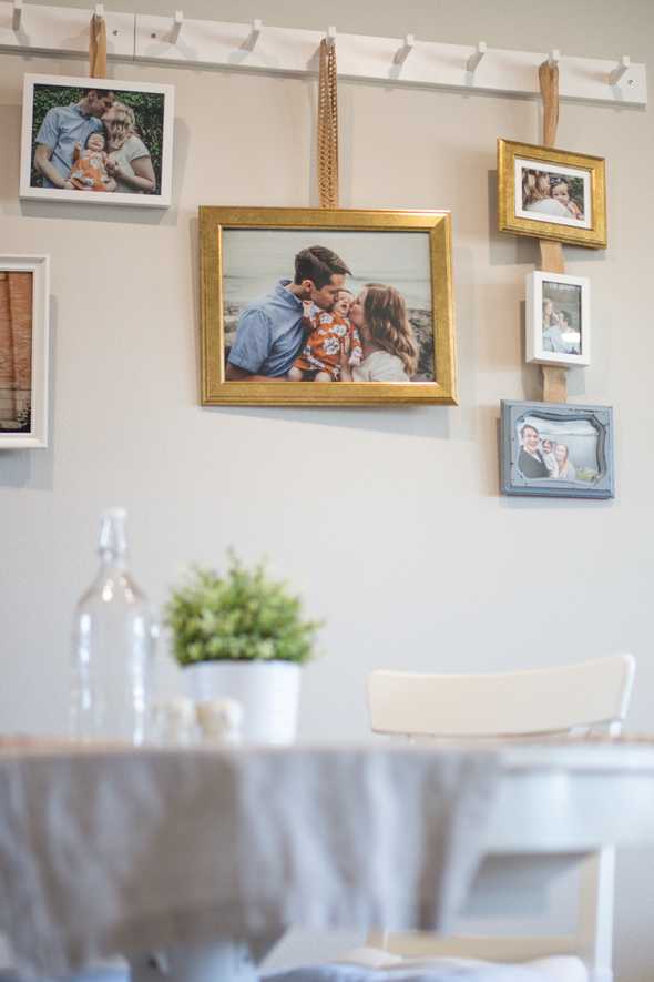 Picture frames hanging on the wall by a kitchen table