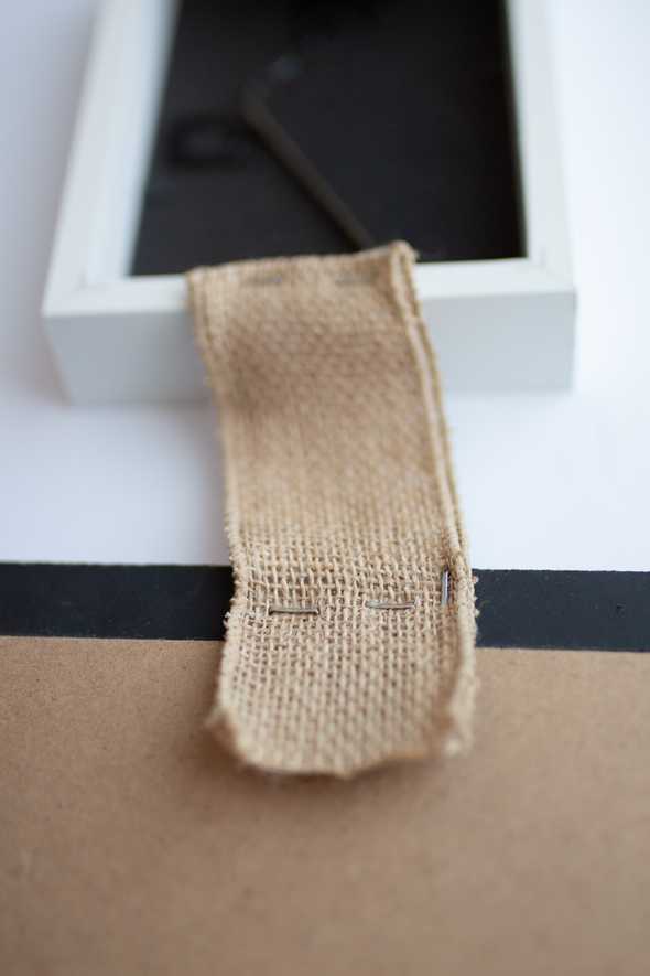 close up of burlap ribbon stapled to a picture frame