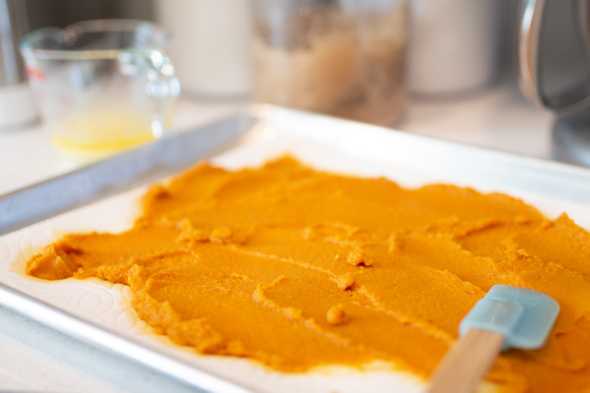 pumpkin puree spread out over a cookie sheet
